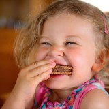 littel girl is eating sweets